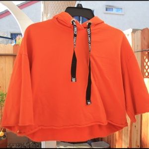Bright orange oversized crop top.